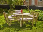 Runder Picknicktisch aus Holz im Garten auf grünem Gras.