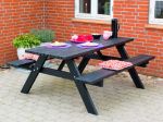 Rechteckiger Picknicktisch aus Holz in der Farbe Schwarz auf einer Terrasse ohne Rückenlehne.