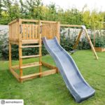 Plus Play Spielturm mit Schaukelbalken und grauschwarzer Rutsche 460 x 395 x 200 cm im Garten auf der Wiese