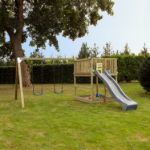 Plus Play Spielturm mit Schaukelbalken und grauschwarzer Rutsche 460 x 395 x 200 cm im Garten auf der Wiese